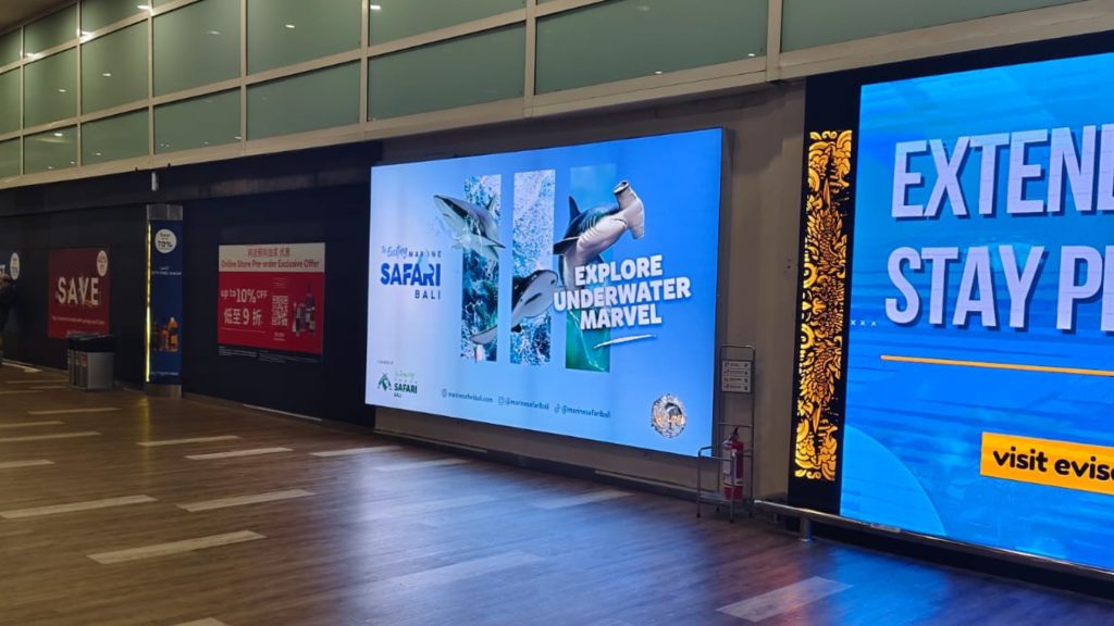 Bali Safari lightbox positioned right after immigration at Ngurah Rai Airport, strategically placed as the first visual seen by passengers after passport control.