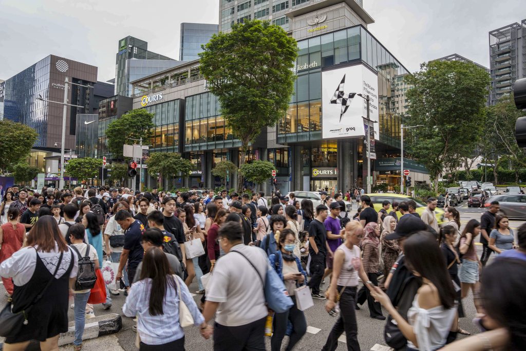 LED screen advertising at The Heeren on Orchard Road, Singapore, featuring a Groq campaign displayed on a prominent digital billboard facing heavy pedestrian traffic