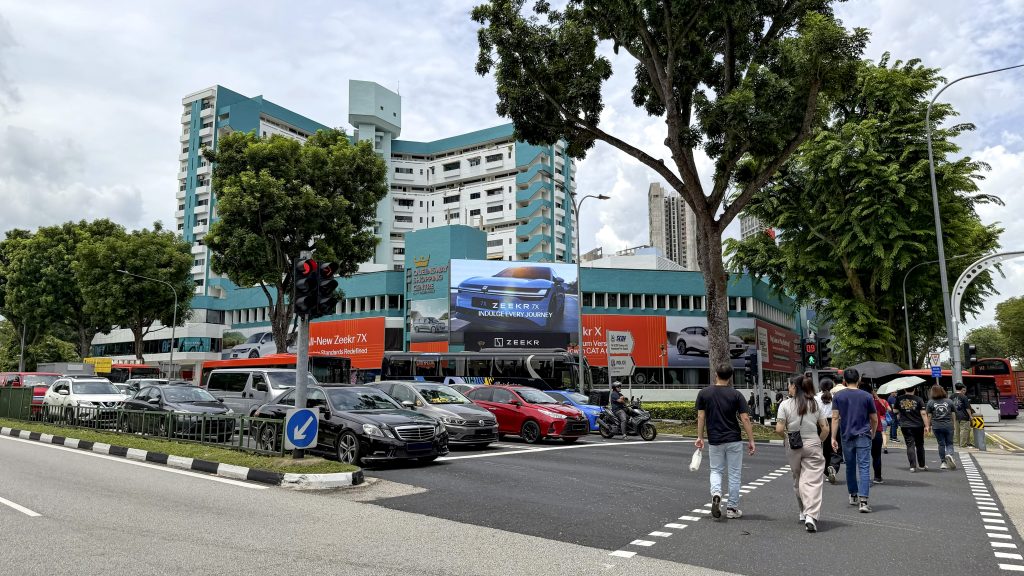 Zeekr electric vehicle campaign on a large-format DOOH LED screen at Queensway Shopping Centre Singapore, high-traffic roadside outdoor advertising location.